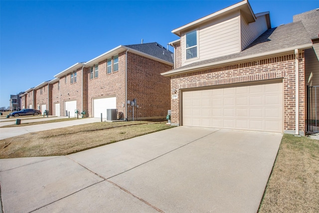 exterior space with driveway, brick siding, a front yard, and cooling unit