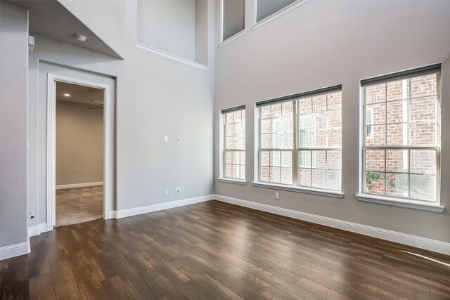 interior space with dark hardwood / wood-style flooring and a towering ceiling