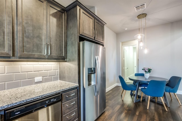 kitchen featuring dark brown cabinetry, visible vents, appliances with stainless steel finishes, dark wood finished floors, and pendant lighting