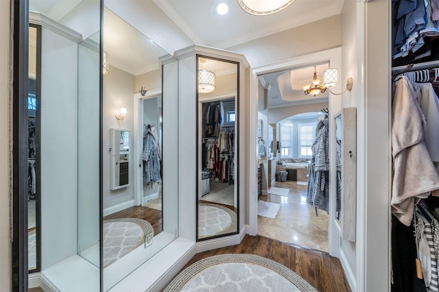 bathroom featuring hardwood / wood-style floors, crown molding, and a notable chandelier