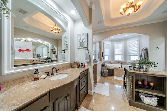 bathroom featuring vanity, a bath, an inviting chandelier, a raised ceiling, and ornamental molding