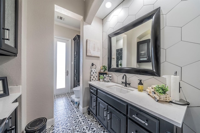 bathroom featuring crown molding, plenty of natural light, vanity, and toilet