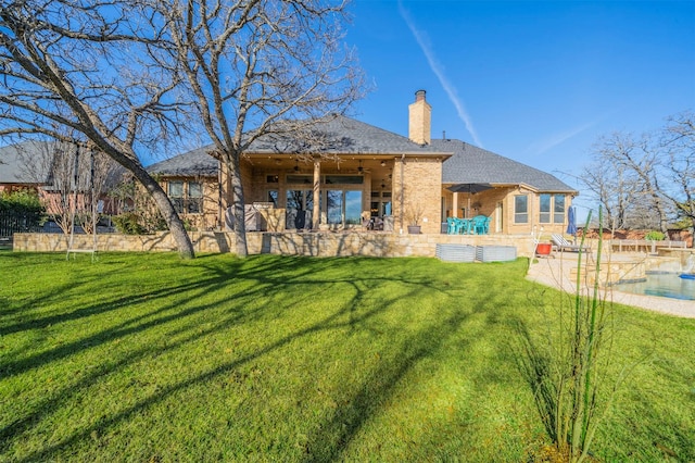 back of house with a lawn and a patio