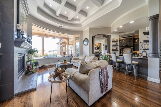 living room with decorative columns, ornamental molding, coffered ceiling, beamed ceiling, and a fireplace