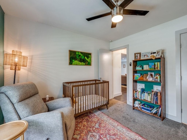 bedroom featuring ceiling fan, carpet, and a crib