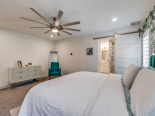 carpeted bedroom with connected bathroom, a barn door, and ceiling fan