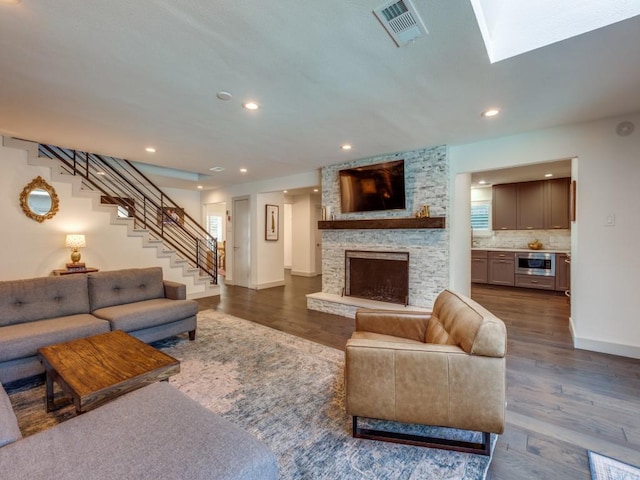 living room with a fireplace and dark wood-type flooring