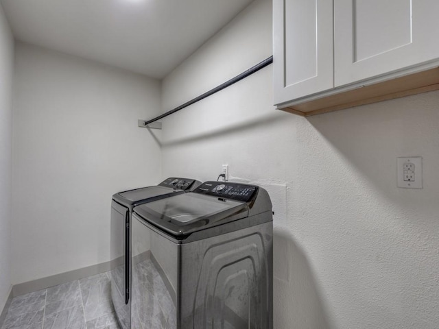 washroom with cabinets and washing machine and dryer