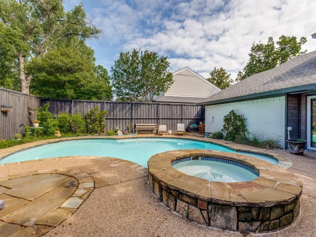 view of swimming pool with an in ground hot tub