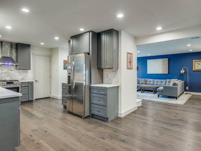 kitchen featuring backsplash, gray cabinets, wall chimney exhaust hood, and stainless steel appliances