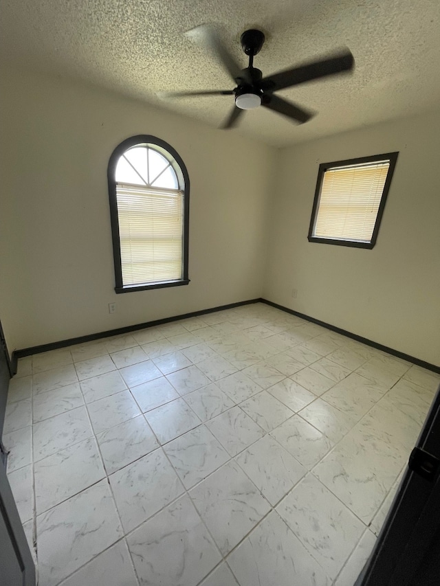 spare room featuring a textured ceiling and ceiling fan