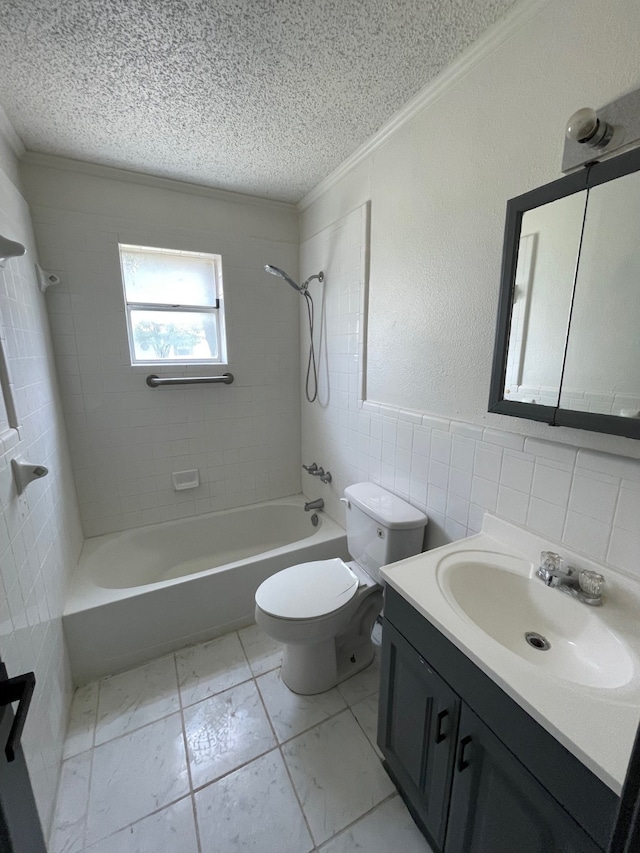 full bathroom featuring ornamental molding, vanity, tiled shower / bath combo, tile walls, and toilet