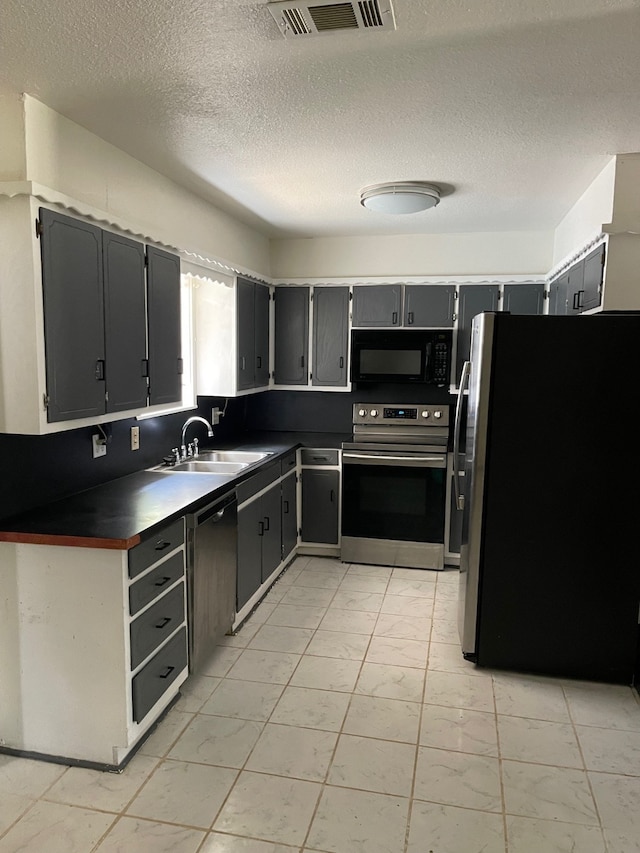 kitchen featuring a textured ceiling, sink, and appliances with stainless steel finishes