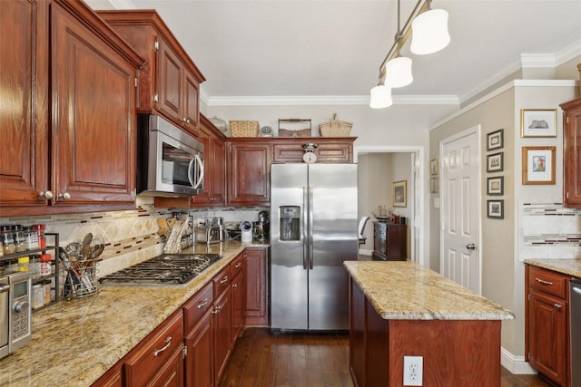 kitchen featuring decorative backsplash, hanging light fixtures, light stone countertops, stainless steel appliances, and ornamental molding