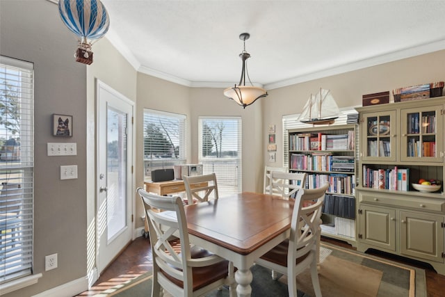 dining area with a healthy amount of sunlight, dark hardwood / wood-style flooring, and ornamental molding