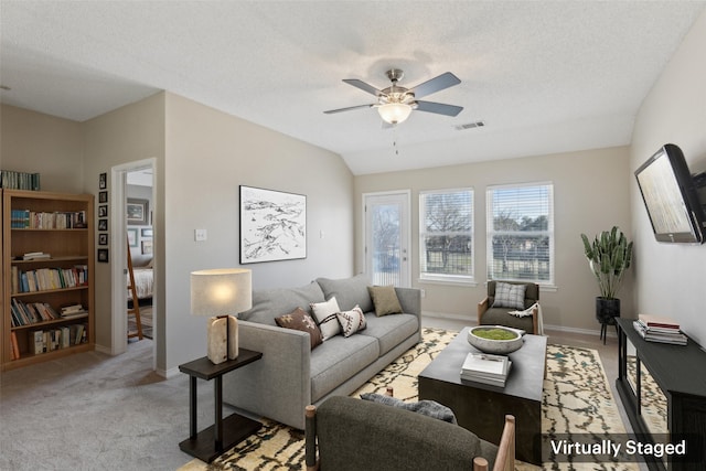 living room featuring ceiling fan, a textured ceiling, and light carpet