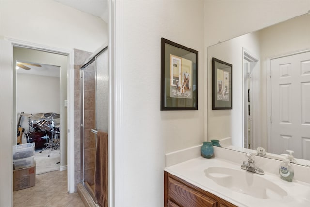 bathroom with ceiling fan, tile patterned floors, walk in shower, and vanity