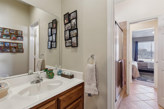 bathroom featuring ceiling fan, tile patterned flooring, a shower with door, and vanity