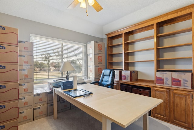 office space featuring ceiling fan, light colored carpet, and a textured ceiling