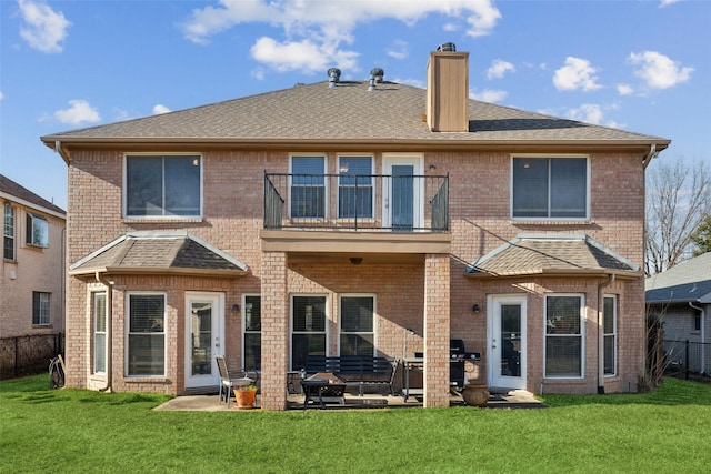 back of property with a patio area, a lawn, and a balcony