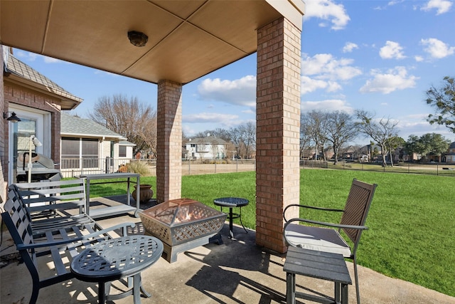 view of patio / terrace featuring a sunroom and an outdoor fire pit