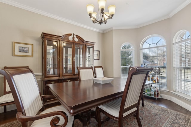 dining room with dark hardwood / wood-style floors, crown molding, a chandelier, and a healthy amount of sunlight