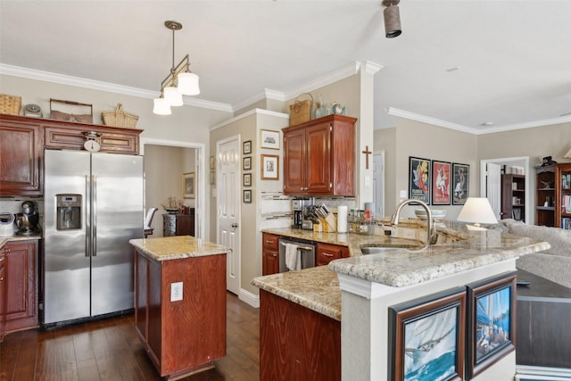 kitchen featuring decorative light fixtures, kitchen peninsula, sink, crown molding, and stainless steel appliances