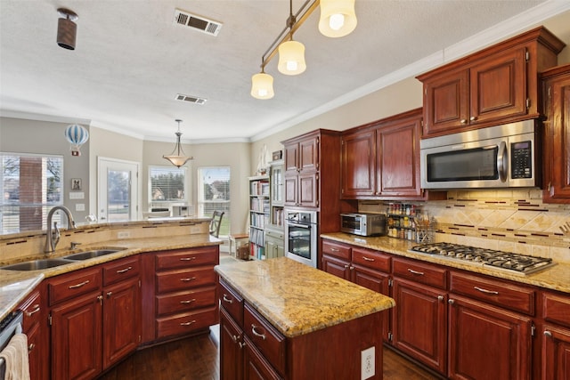 kitchen featuring tasteful backsplash, a center island, pendant lighting, sink, and stainless steel appliances