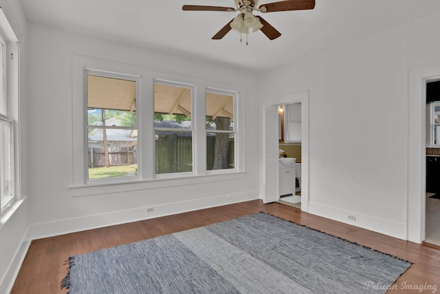 spare room with ceiling fan and dark wood-type flooring