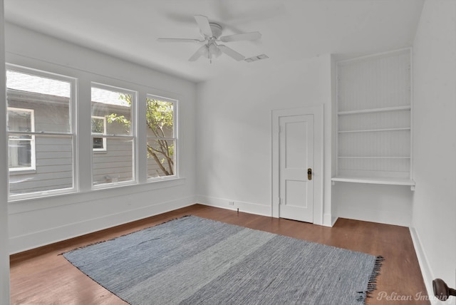 unfurnished room featuring ceiling fan and dark wood-type flooring