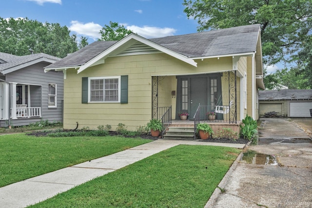 bungalow featuring an outdoor structure and a front lawn