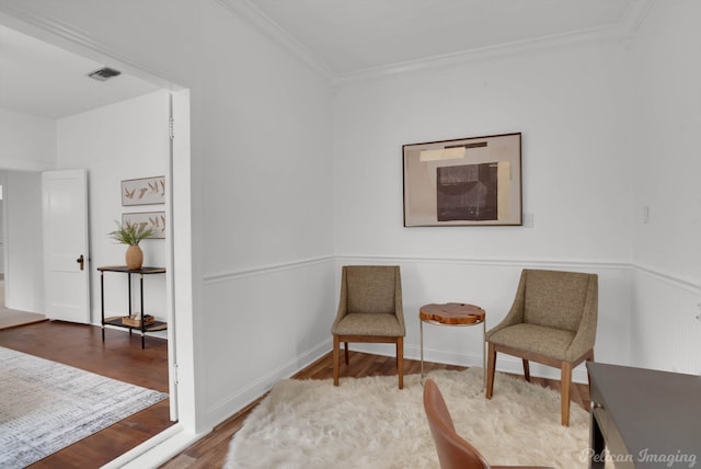 sitting room featuring hardwood / wood-style floors and ornamental molding