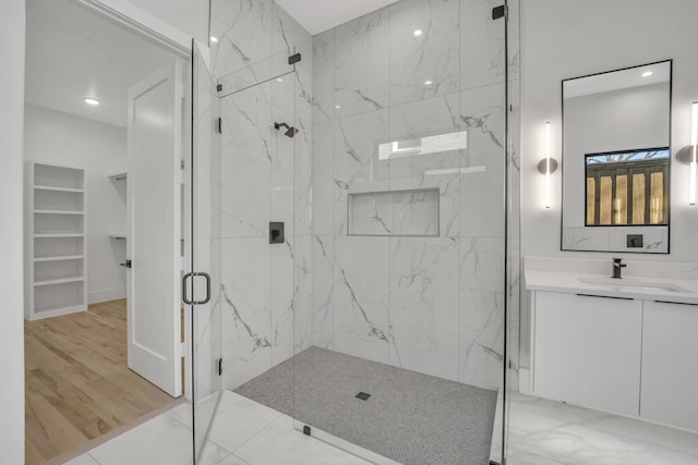 bathroom with a shower with door and vanity