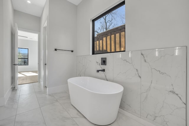 bathroom featuring a bathing tub and tile walls