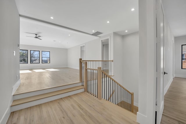 staircase featuring hardwood / wood-style floors and ceiling fan