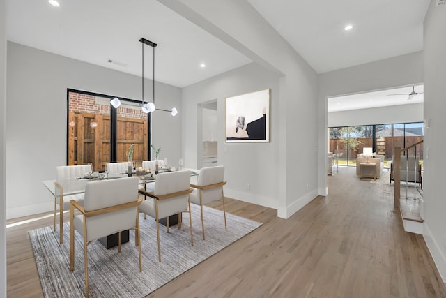 dining space with ceiling fan and light wood-type flooring