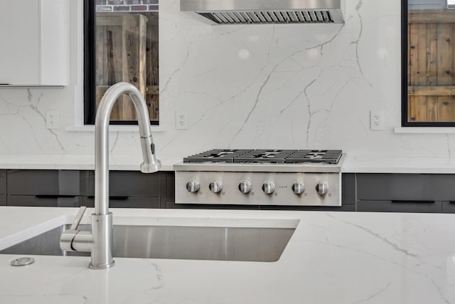 kitchen with sink, white cabinets, range hood, and stainless steel gas stovetop