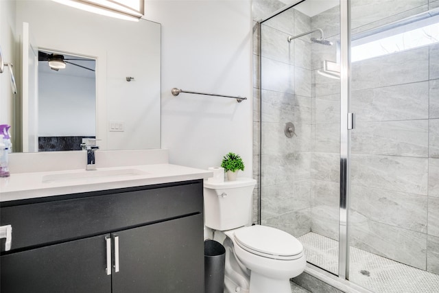 bathroom with a shower with door, vanity, and toilet