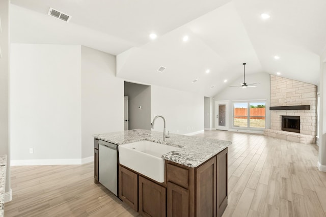 489 Red Maple Rd, Waxahachie, TX 75165 - kitchen featuring stainless steel dishwasher, a sink, ceiling fan, light wood-type flooring, and a stone fireplace