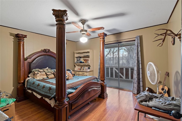 bedroom with access to exterior, wood-type flooring, and ceiling fan