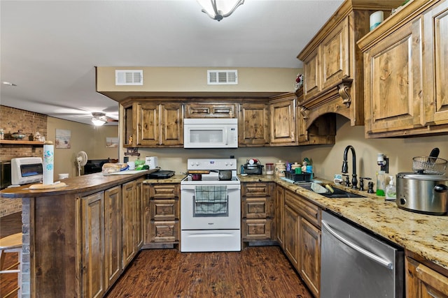 kitchen with white appliances, sink, dark hardwood / wood-style flooring, kitchen peninsula, and a breakfast bar area