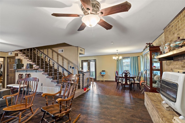 dining room featuring dark hardwood / wood-style floors, ceiling fan with notable chandelier, and heating unit