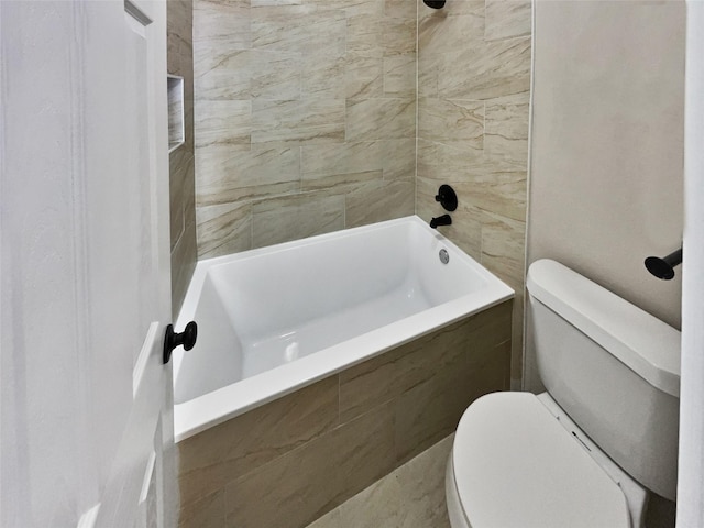 bathroom with toilet and tiled shower / bath