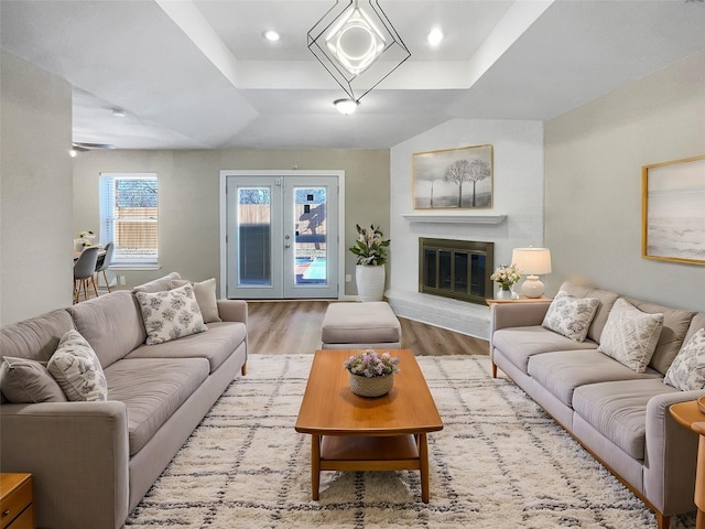 living room featuring a raised ceiling and light wood-type flooring