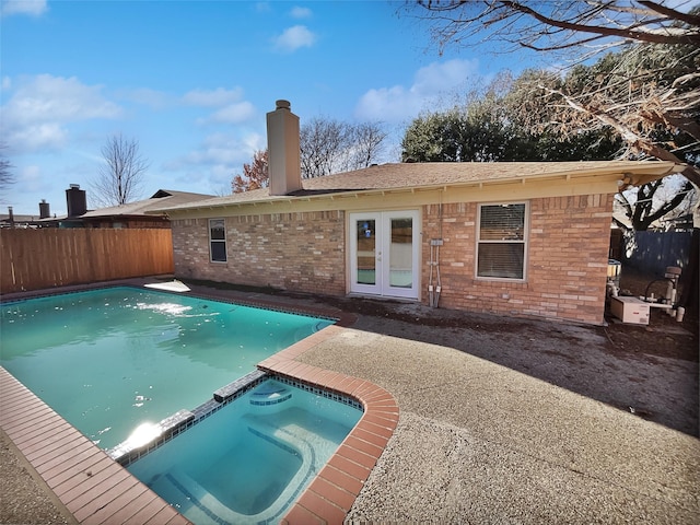 view of swimming pool featuring french doors and an in ground hot tub