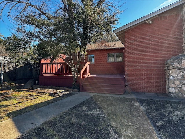 exterior space featuring brick siding and a deck