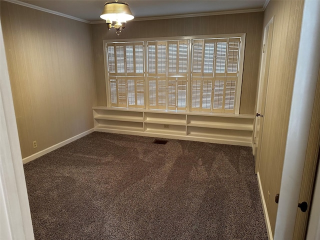 carpeted empty room with an inviting chandelier, baseboards, and ornamental molding