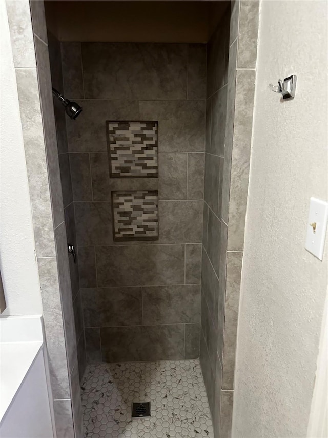 full bathroom featuring vanity, a shower stall, and a textured wall