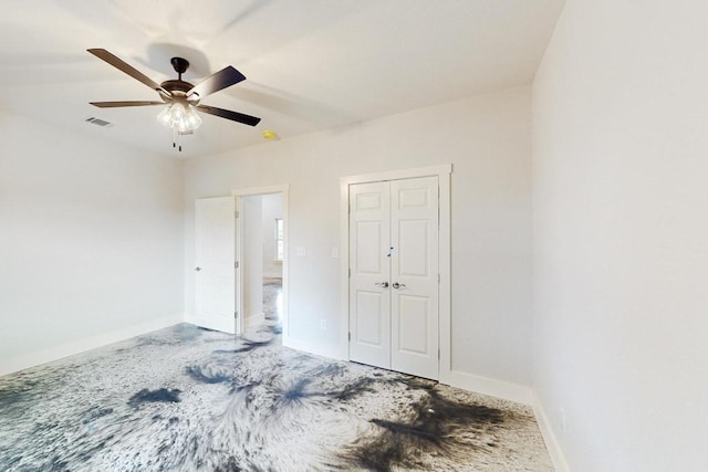 unfurnished bedroom with ceiling fan and a closet