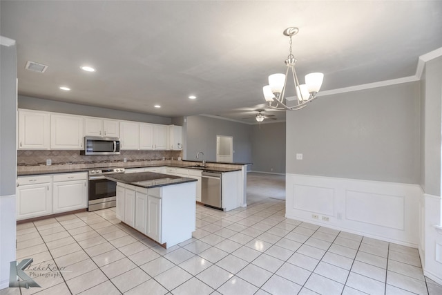 kitchen featuring white cabinetry, stainless steel appliances, kitchen peninsula, and pendant lighting